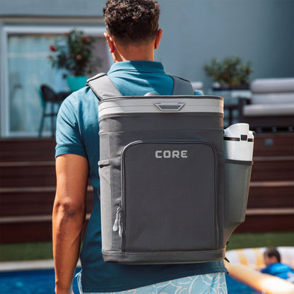 A person carrying the CORE 26 can Flipback backpack cooler around the pool. 